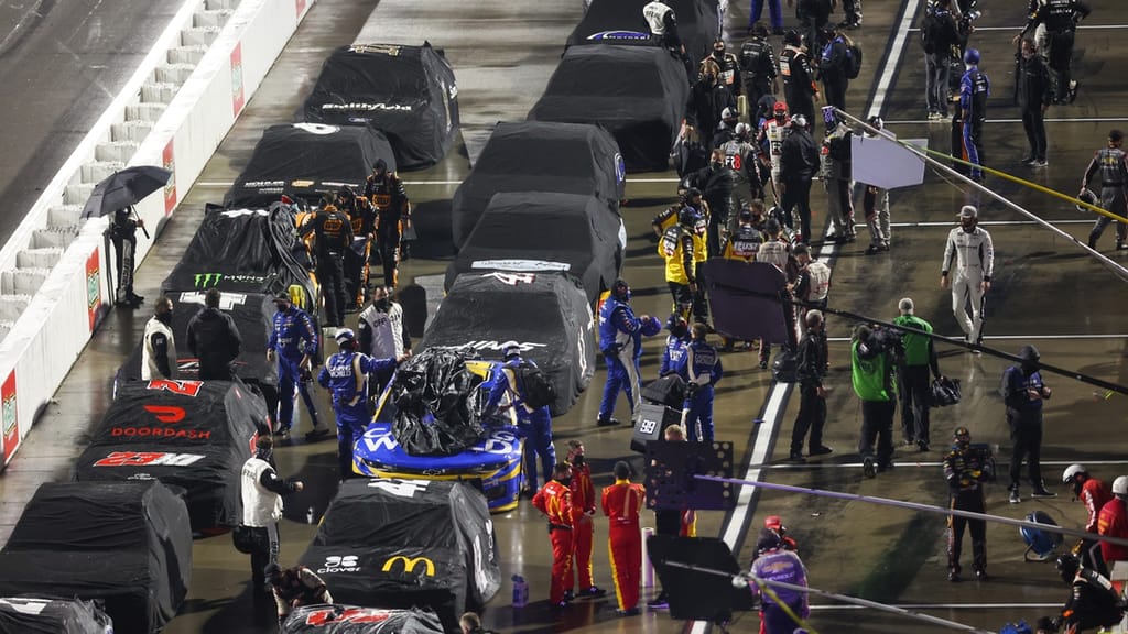 Apr 10, 2021; Martinsville, Virginia, USA; NASCAR Cup Series pit crews cover cars during a rain delay during the Blue-Emu Maximum Pain Relief 500 at Martinsville Speedway. Mandatory Credit: Ryan Hunt-USA TODAY Sports