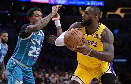 Dec 28, 2023; Los Angeles, California, USA;  Charlotte Hornets forward P.J. Washington (25) defends Los Angeles Lakers forward LeBron James (23) in the first half at Crypto.com Arena. Mandatory Credit: Jayne Kamin-Oncea-USA TODAY Sports