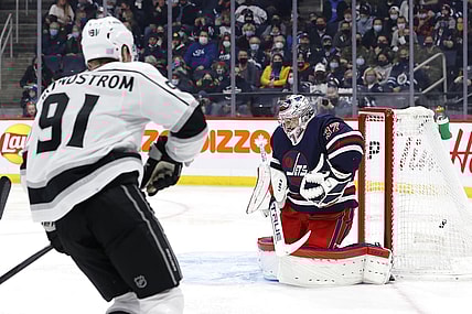 Nov 13, 2021; Winnipeg, Manitoba, CAN; Los Angeles Kings left wing Carl Grundstrom (91) scores a goal on Winnipeg Jets goaltender Connor Hellebuyck (37) in the first period at Canada Life Centre. Mandatory Credit: James Carey Lauder-USA TODAY Sports