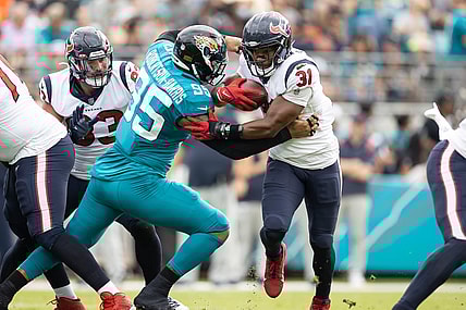 Dec 19, 2021; Jacksonville, Florida, USA; Houston Texans running back David Johnson (31) runs past Jacksonville Jaguars defensive end Roy Robertson-Harris (95) during the first half at TIAA Bank Field. Mandatory Credit: Matt Pendleton-USA TODAY Sports