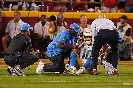 Sep 15, 2022; Kansas City, Missouri, USA; Los Angeles Chargers quarterback Justin Herbert (10) is looked at by team trainers after being hit by Kansas City Chiefs defensive end Mike Danna (51) during the second half at GEHA Field at Arrowhead Stadium. Mandatory Credit: Jay Biggerstaff-USA TODAY Sports