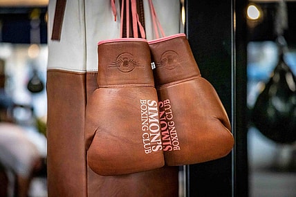 A pair of boxing gloves hang inside Simon  s Boxing Club January 23, 2023. Simon "The Phoenix" Bakinde was born in Cameroon, Central Africa and grew up in a small impoverished village named Omeng.