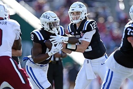 Dec 23, 2023; Birmingham, AL, USA; Duke Blue Devils quarterback Grayson Loftis (12) hands the ball off to Duke Blue Devils running back Jaquez Moore (9) during the first half against the Troy Trojans at Protective Stadium. Mandatory Credit: Petre Thomas-USA TODAY Sports