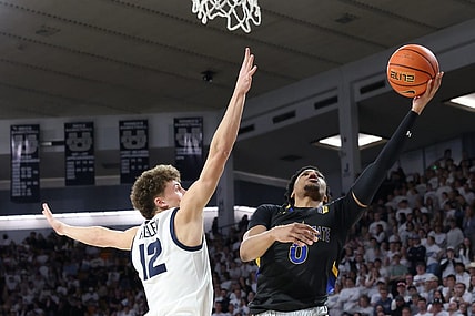Jan 30, 2024; Logan, Utah, USA; San Jose State Spartans guard Myron Amey Jr. (0) lays the ball up against Utah State Aggies guard Mason Falslev (12) during the first half at Dee Glen Smith Spectrum. Mandatory Credit: Rob Gray-USA TODAY Sports