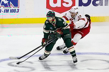 Feb 27, 2024; Saint Paul, Minnesota, USA; Minnesota Wild right wing Ryan Hartman (38) skates with the pucka as Carolina Hurricanes defenseman Brett Pesce (22) defends  during the third period at Xcel Energy Center. Mandatory Credit: Matt Krohn-USA TODAY Sports