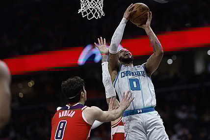 Mar 8, 2024; Washington, District of Columbia, USA; Charlotte Hornets forward Miles Bridges (0) shoots the ball as Washington Wizards forward Kyle Kuzma (33) and Wizards forward Deni Avdija (8) defend in the second half at Capital One Arena. Mandatory Credit: Geoff Burke-USA TODAY Sports