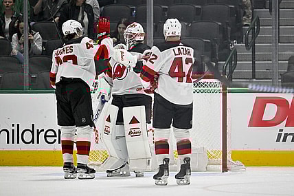 Mar 14, 2024; Dallas, Texas, USA; New Jersey Devils defenseman Luke Hughes (43) and center Curtis Lazar (42) and goaltender Jake Allen (34) celebrate on the ice after the Devils defeat the Dallas Stars at the American Airlines Center. Mandatory Credit: Jerome Miron-USA TODAY Sports