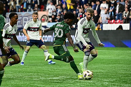 Mar 30, 2024; Vancouver, British Columbia, CAN; Portland Timbers forward Santiago Moreno (30) shoots as Vancouver Whitecaps FC defender Tristan Blackmon (6) defends during the first half at BC Place. Mandatory Credit: Simon Fearn-USA TODAY Sports