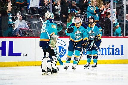 New York Sirens forward Savannah Norcross celebrates a win over the Vancouver Goldeneyes with goalie Kayle Osborne.