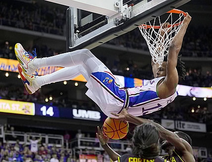 Dec 30, 2023; Kansas City, Missouri, USA; Kansas Jayhawks guard Elmarko Jackson (13) dunks against Wichita State Shockers center Quincy Ballard (15) and guard Bijan Cortes (55) during the first half at T-Mobile Center. Mandatory Credit: Jay Biggerstaff-USA TODAY Sports