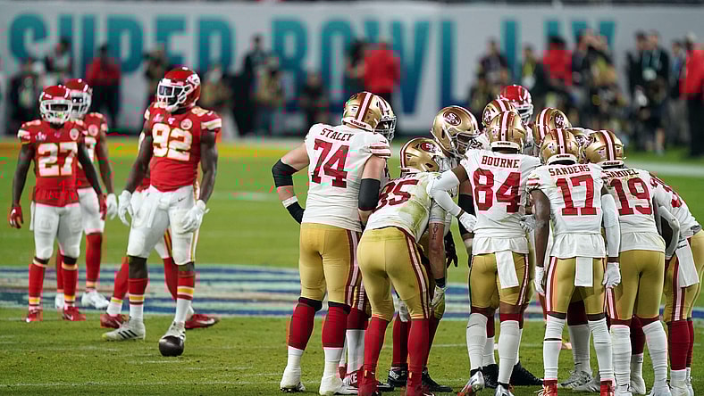 NFL players on the San Francisco 49ers and Kansas City Chiefs huddle