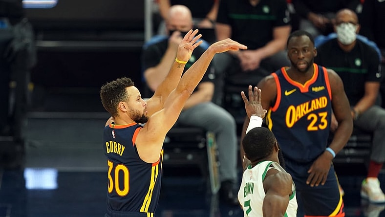 Feb 2, 2021; San Francisco, California, USA; Golden State Warriors guard Stephen Curry (30) hits a 3 pointer over Boston Celtics guard Jaylen Brown (7) during the first quarter at Chase Center. Mandatory Credit: Darren Yamashita-USA TODAY Sports