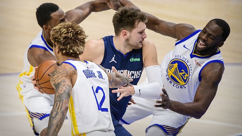 Feb 6, 2021; Dallas, Texas, USA; Dallas Mavericks guard Luka Doncic (77) drives to the basket past Golden State Warriors forward Andrew Wiggins (22) and guard Kelly Oubre Jr. (12) and forward Draymond Green (23) during the first quarter at the American Airlines Center. Mandatory Credit: Jerome Miron-USA TODAY Sports