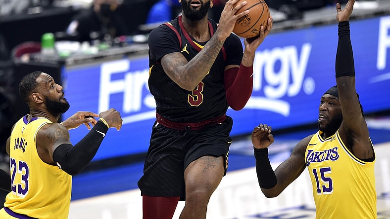 Jan 25, 2021; Cleveland, Ohio, USA; Cleveland Cavaliers center Andre Drummond (3) drives between Los Angeles Lakers forward LeBron James (23) and center Montrezl Harrell (15) in the first quarter at Rocket Mortgage FieldHouse. Mandatory Credit: David Richard-USA TODAY Sports