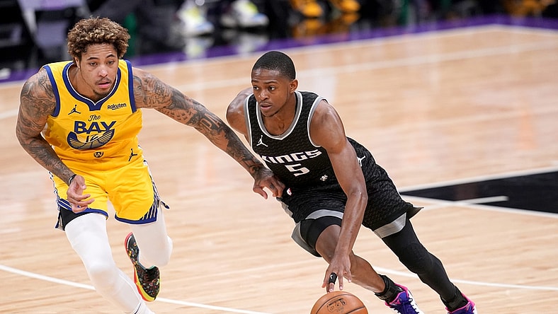 Mar 25, 2021; Sacramento, California, USA; Sacramento Kings guard De'Aaron Fox (5) dribbles past Golden State Warriors forward Kelly Oubre Jr. (12) in the third quarter at the Golden 1 Center. Mandatory Credit: Cary Edmondson-USA TODAY Sports