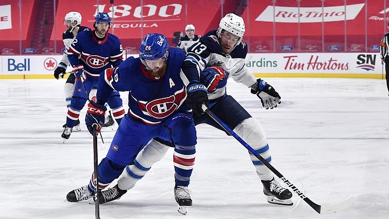 Apr 10, 2021; Montreal, Quebec, CAN; Montreal Canadiens defenseman Jeff Petry (26) plays the puck against Winnipeg Jets forward Pierre-Luc Dubois (13) during the first period at the Bell Centre. Mandatory Credit: Eric Bolte-USA TODAY Sports