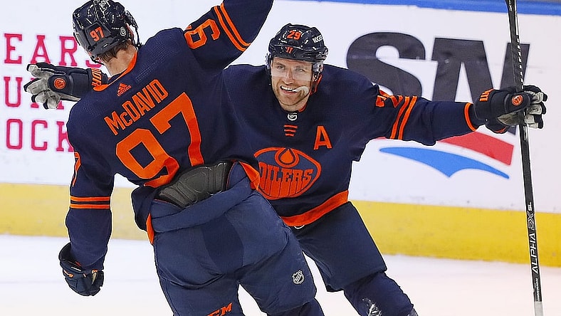 May 8, 2021; Edmonton, Alberta, CAN; Edmonton Oilers forward Connor McDavid (97) celebrates his 100th point of the season on a goal by forward Leon Draisaitl (29) against the Vancouver Canucks at Rogers Place. Mandatory Credit: Perry Nelson-USA TODAY Sports