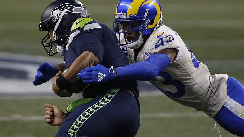 Jan 9, 2021; Seattle, Washington, USA; Los Angeles Rams safety John Johnson III (43) tackles Seattle Seahawks quarterback Russell Wilson (3) during the fourth quarter at Lumen Field. Mandatory Credit: Joe Nicholson-USA TODAY Sports