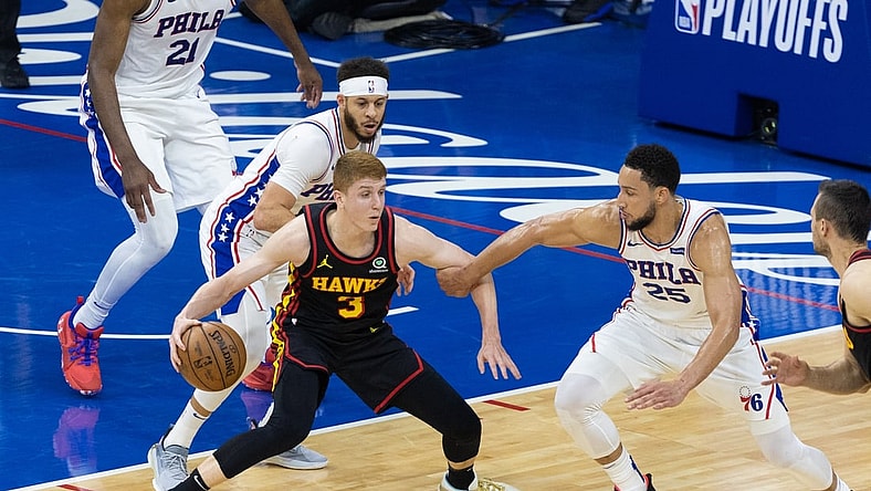 Jun 20, 2021; Philadelphia, Pennsylvania, USA; Atlanta Hawks guard Kevin Huerter (3) controls the ball against Philadelphia 76ers guard Ben Simmons (25) and guard Seth Curry (31) during the second quarter of game seven of the second round of the 2021 NBA Playoffs at Wells Fargo Center. Mandatory Credit: Bill Streicher-USA TODAY Sports