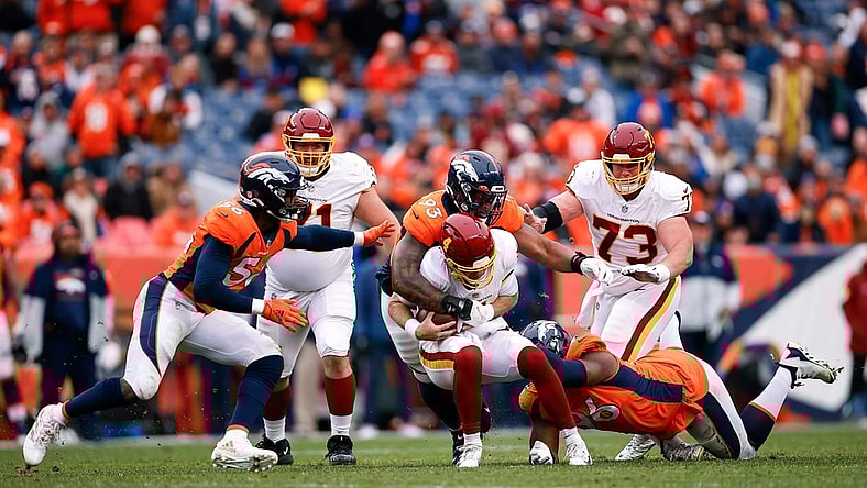 Oct 31, 2021; Denver, Colorado, USA; Washington Football Team quarterback Taylor Heinicke (4) is sacked by Denver Broncos defensive end Shelby Harris (96) and defensive end Dre'Mont Jones (93) as guard Wes Schweitzer (71) and center Chase Roullier (73) and linebacker Baron Browning (56) defend in the second quarter at Empower Field at Mile High. Mandatory Credit: Isaiah J. Downing-USA TODAY Sports