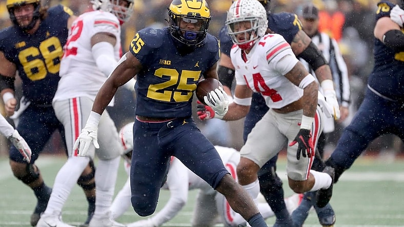 Michigan Wolverines running back Hassan Haskins runs by Ohio State Buckeyes safety Ronnie Hickman during the first half Saturday, Nov. 27, 2021, Michigan Stadium.

Michigan Ohio