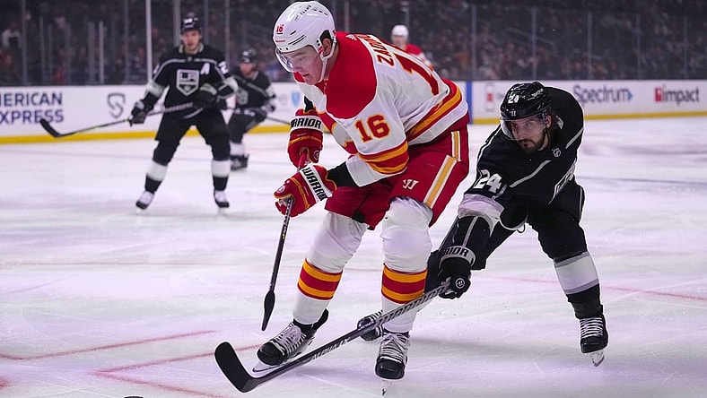 Dec 2, 2021; Los Angeles, California, USA; Calgary Flames defenseman Nikita Zadorov (16) and LA Kings left wing Phillip Danault (24) battle for the puck in the first period at Staples Center. Mandatory Credit: Kirby Lee-USA TODAY Sports