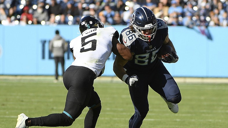 Dec 12, 2021; Nashville, Tennessee, USA;  Tennessee Titans tight end Anthony Firkser (86) runs through the tackle of Jacksonville Jaguars defensive back Rudy Ford (5) during the first half at Nissan Stadium. Mandatory Credit: Steve Roberts-USA TODAY Sports