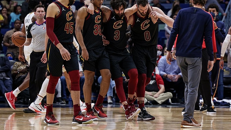Dec 28, 2021; New Orleans, Louisiana, USA; Cleveland Cavaliers guard Ricky Rubio (3) is helped off the court by forward Kevin Love (0) and forward Isaac Okoro (35) after injuring his ankle against New Orleans Pelicans forward Herbert Jones (5) during the second half at Smoothie King Center. Mandatory Credit: Stephen Lew-USA TODAY Sports