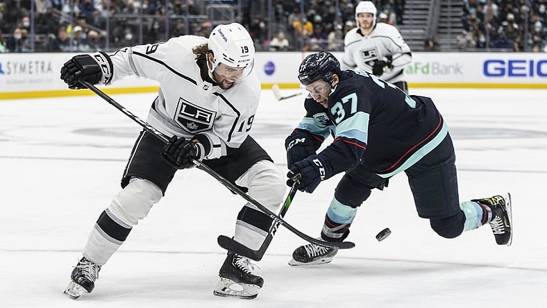 Jan 15, 2022; Seattle, Washington, USA; Los Angeles Kings left wing Alex Iafallo (19) and Seattle Kraken center Yanni Gourde(37) battle for the puck during the second period at Climate Pledge Arena. Mandatory Credit: Stephen Brashear-USA TODAY Sports