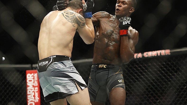 Feb 12, 2022; Houston, Texas, UNITED STATES; Israel Adesanya (red gloves) fights Robert Whittaker (blue gloves) during UFC 271 at Toyota Center. Mandatory Credit: Troy Taormina-USA TODAY Sports
