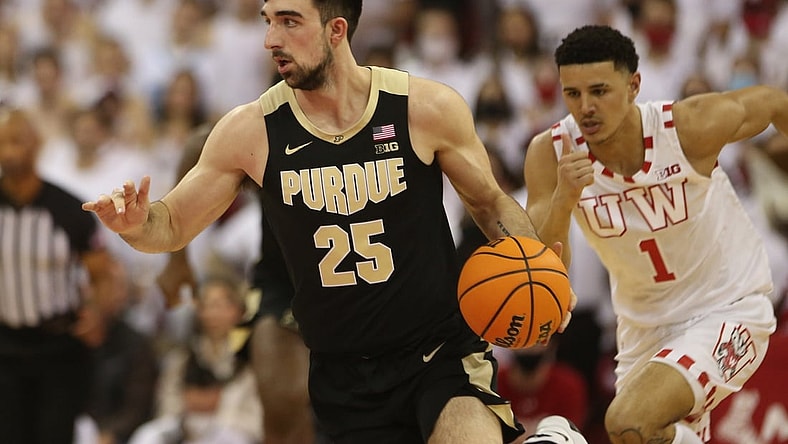 Mar 1, 2022; Madison, Wisconsin, USA; Purdue Boilermakers guard Ethan Morton (25) brings the ball up the floor as Wisconsin Badgers guard Johnny Davis (1) follows during the first half at the Kohl Center. Mandatory Credit: Mary Langenfeld-USA TODAY Sports