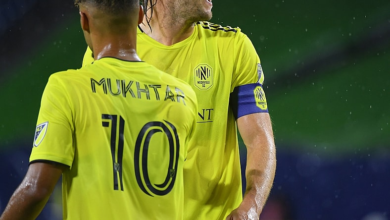 Aug 18, 2021; Nashville, TN, USA; Nashville SC defender Walker Zimmerman (25) and Nashville SC midfielder Hany Mukhtar (10) celebrate after a goal by Nashville SC forward C.J. Sapong (not pictured) during the first half against the Orlando City at Nissan Stadium. Mandatory Credit: Christopher Hanewinckel-USA TODAY Sports