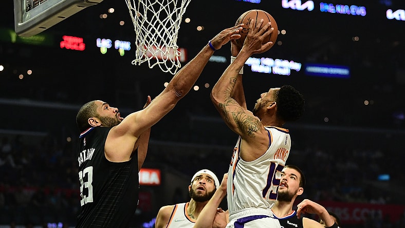 Apr 6, 2022; Los Angeles, California, USA; Phoenix Suns guard Cameron Payne (15) shoots against Los Angeles Clippers forward Nicolas Batum (33) during the first half at Crypto.com Arena. Mandatory Credit: Gary A. Vasquez-USA TODAY Sports