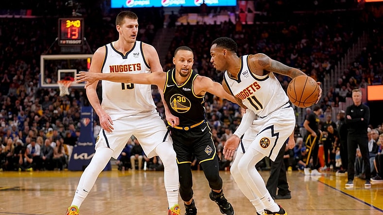 Apr 16, 2022; San Francisco, California, USA; Golden State Warriors guard Stephen Curry (30) reaches past Denver Nuggets center Nikola Jokic (15) to pressure guard Monte Morris (11) in the first quarter during game one of the first round for the 2022 NBA playoffs at the Chase Center. Mandatory Credit: Cary Edmondson-USA TODAY Sports