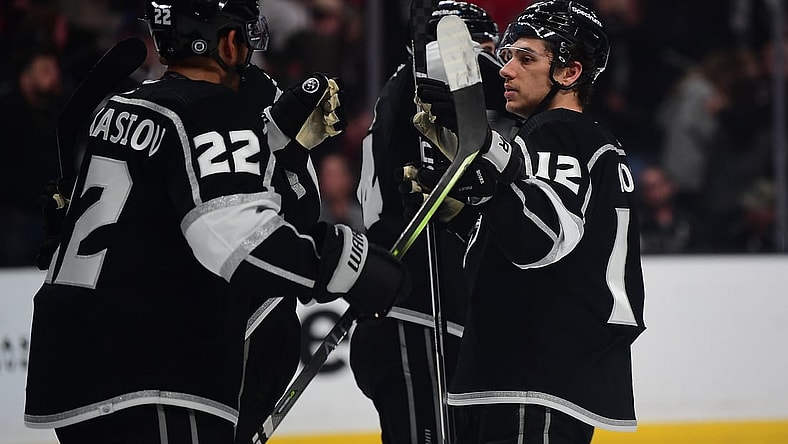 Apr 21, 2022; Los Angeles, California, USA; Los Angeles Kings center Trevor Moore (12) and center Andreas Athanasiou (22) celebrate the victory against the Chicago Blackhawks at Crypto.com Arena. Mandatory Credit: Gary A. Vasquez-USA TODAY Sports