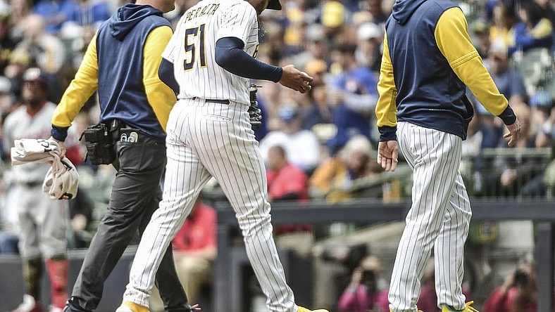 May 22, 2022; Milwaukee, Wisconsin, USA;  Milwaukee Brewers pitcher Freddy Peralta (51) leaves the game with manager Craig Counsell after experiencing right shoulder tightness in the fourth inning during game against the Washington Nationals at American Family Field. Mandatory Credit: Benny Sieu-USA TODAY Sports