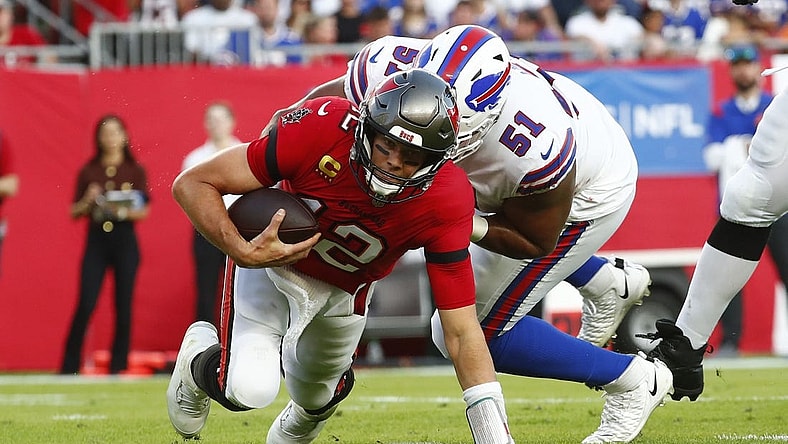 Dec 12, 2021; Tampa, Florida, USA; Tampa Bay Buccaneers quarterback Tom Brady (12) runs with the ball as Buffalo Bills defensive end Bryan Cox (51) defends during the first half at Raymond James Stadium. Mandatory Credit: Kim Klement-USA TODAY Sports