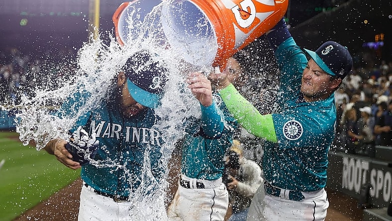Jul 8, 2022; Seattle, Washington, USA; Seattle Mariners third baseman Eugenio Suarez (28) is doused with water by designated hitter Ty France (23, right) after hitting a walk-off home run against the Toronto Blue Jays during the eleventh inning at T-Mobile Park. Mandatory Credit: Joe Nicholson-USA TODAY Sports