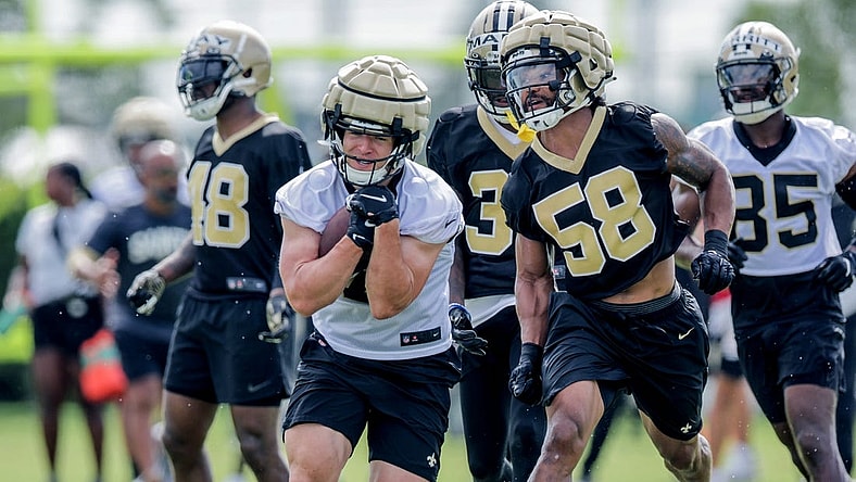 Jul 28, 2022; Metairie, LA, USA; New Orleans Saints linebacker Eric Wilson (58) attempts to punch the ball from quarterback Taysom Hill (7) during training camp at Ochsner Sports Performance Center. Mandatory Credit: Stephen Lew-USA TODAY Sports