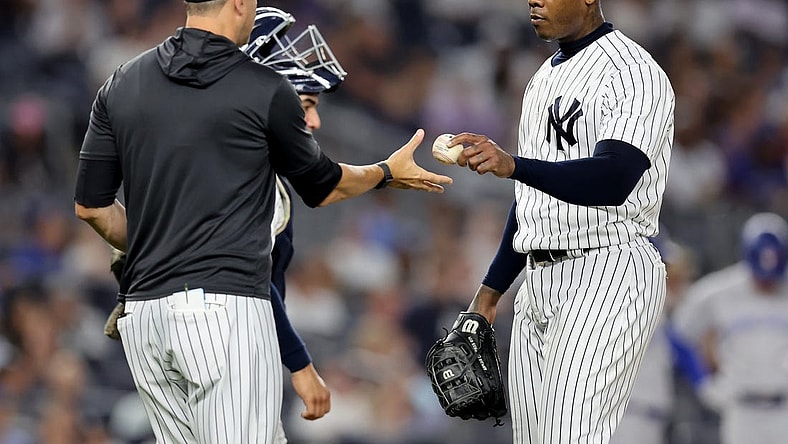 Aug 19, 2022; Bronx, New York, USA; New York Yankees relief pitcher Aroldis Chapman (54) hands the ball to manager Aaron Boone (17) after being taken out of the game against the Toronto Blue Jays during the ninth inning at Yankee Stadium. Mandatory Credit: Brad Penner-USA TODAY Sports