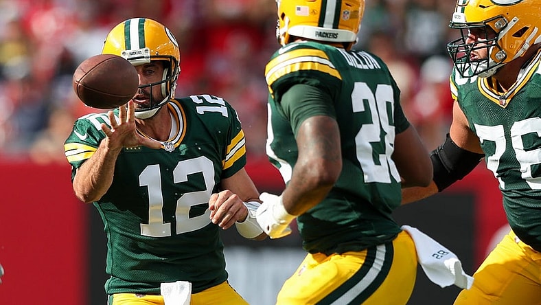 Sep 25, 2022; Tampa, Florida, USA;  Green Bay Packers quarterback Aaron Rodgers (12) shuffles a pass to running back AJ Dillon (28) against the Tampa Bay Buccaneers in the second quarter at Raymond James Stadium. Mandatory Credit: Nathan Ray Seebeck-USA TODAY Sports