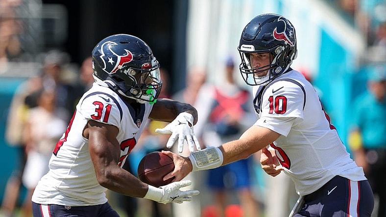 Oct 9, 2022; Jacksonville, Florida, USA; Houston Texans quarterback Davis Mills (10) hands off to Houston Texans running back Dameon Pierce (31) against the Jacksonville Jaguars in the first quarter at TIAA Bank Field. Mandatory Credit: Nathan Ray Seebeck-USA TODAY Sports