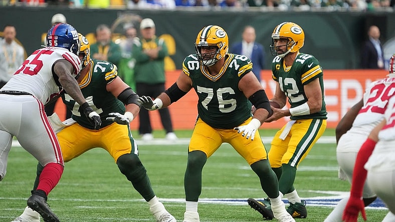 Oct 9, 2022; London, United Kingdom; Green Bay Packers guard Jon Runyan (76) blocks as quarterback Aaron Rodgers (12) drops back to pass against the New York Giants during an NFL International Series game at Tottenham Hotspur Stadium. Mandatory Credit: Kirby Lee-USA TODAY Sports