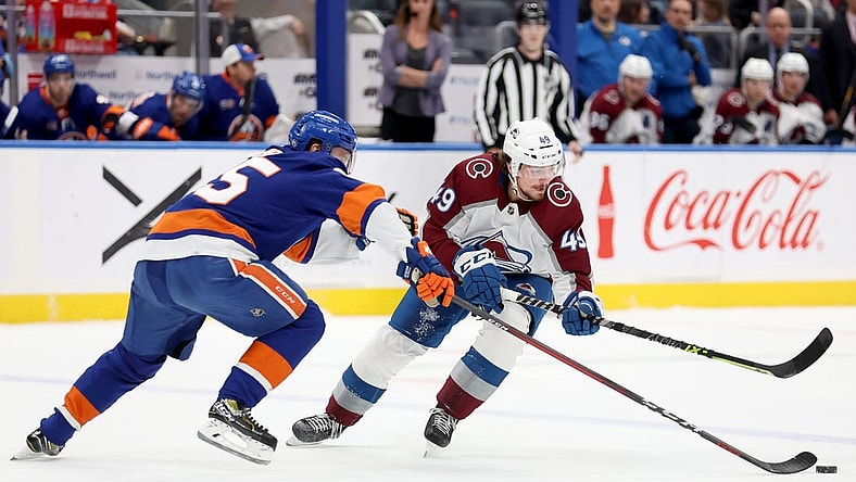 Oct 29, 2022; Elmont, New York, USA; Colorado Avalanche defenseman Samuel Girard (49) and New York Islanders defenseman Sebastian Aho (25) fight for the puck during the first period at UBS Arena. Mandatory Credit: Brad Penner-USA TODAY Sports