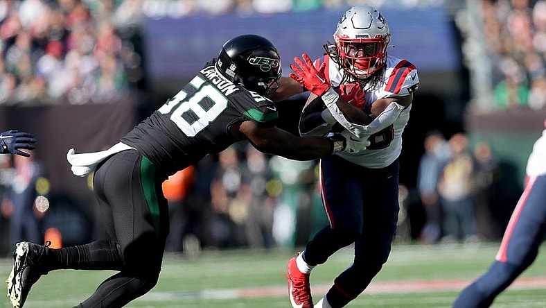 Oct 30, 2022; East Rutherford, New Jersey, USA; New England Patriots running back Rhamondre Stevenson (38) runs with the ball against New York Jets defensive end Carl Lawson (58) during the second quarter at MetLife Stadium. Mandatory Credit: Brad Penner-USA TODAY Sports