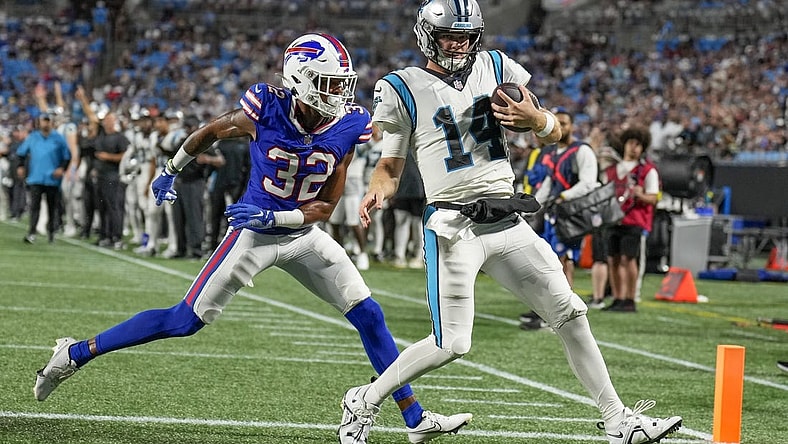Aug 26, 2022; Charlotte, North Carolina, USA; Carolina Panthers quarterback Sam Darnold (14) scores a touchdown while defended by Buffalo Bills cornerback Jordan Miller (32) during the second half at Bank of America Stadium. Mandatory Credit: Jim Dedmon-USA TODAY Sports