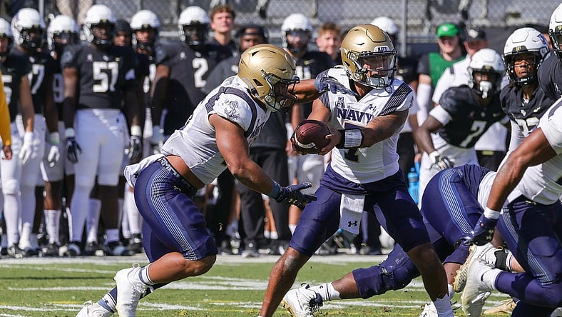 Nov 19, 2022; Orlando, Florida, USA; Navy Midshipmen quarterback Xavier Arline (7) hands off to Navy Midshipmen fullback Daba Fofana (45) during the first quarter at FBC Mortgage Stadium. Mandatory Credit: Mike Watters-USA TODAY Sports