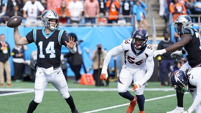 Nov 27, 2022; Charlotte, North Carolina, USA; Carolina Panthers quarterback Sam Darnold (14) throws under pressure from Denver Broncos linebacker Baron Browning (56) during the second quarter at Bank of America Stadium. Mandatory Credit: Jim Dedmon-USA TODAY Sports