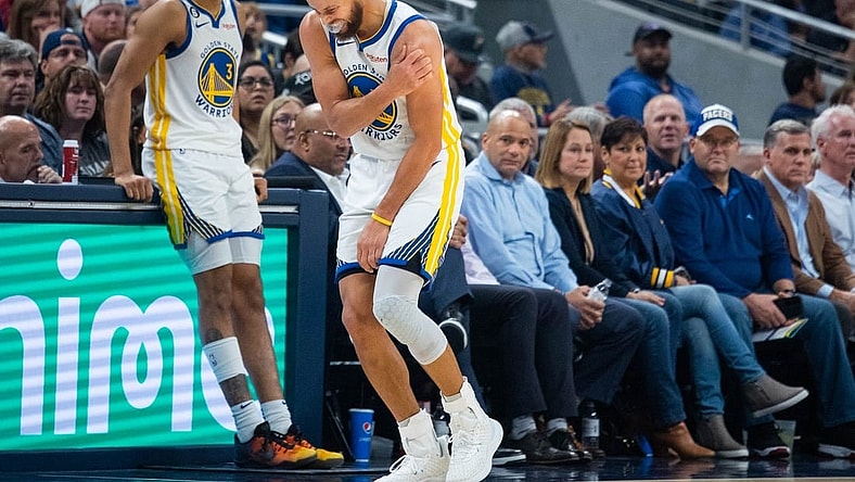 Dec 14, 2022; Indianapolis, Indiana, USA; Golden State Warriors guard Stephen Curry (30) grabs his shoulder in the second half against the Indiana Pacers at Gainbridge Fieldhouse. Mandatory Credit: Trevor Ruszkowski-USA TODAY Sports