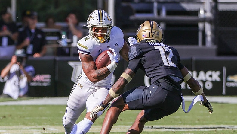 Sep 24, 2022; Orlando, Florida, USA; Georgia Tech Yellow Jackets running back Dontae Smith (4) runs the ball against UCF Knights defensive back Justin Hodges (12) during the first quarter at FBC Mortgage Stadium. Mandatory Credit: Mike Watters-USA TODAY Sports